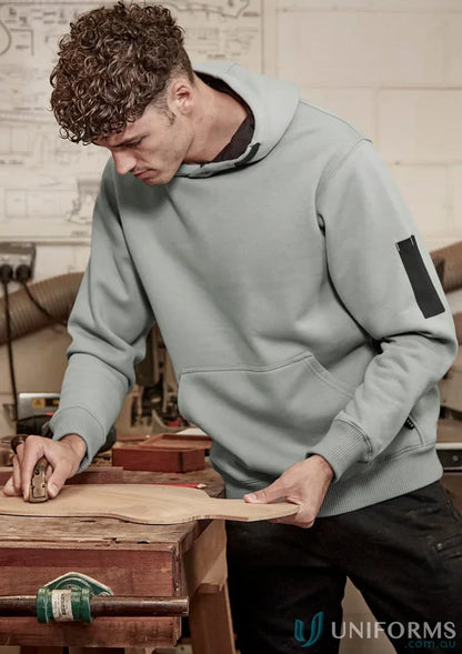 Man in a light blue Syzmic Multi-Pocket Hoodie with reinforced stress points and soft fleece lining
