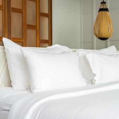 White bed with pillows in a bedroom setting