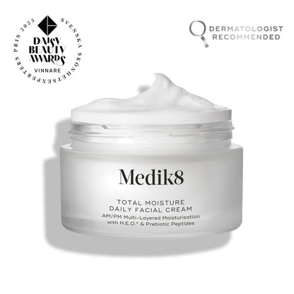 An open frosted glass jar of Medik8 Total Moisture Daily Facial Cream with a peak of white cream on top, set against a clean white background. Badges in the top corners indicate it is a "Daisy Beauty Awards Vinnare 2025" (Winner) and "Dermatologist Recommended."