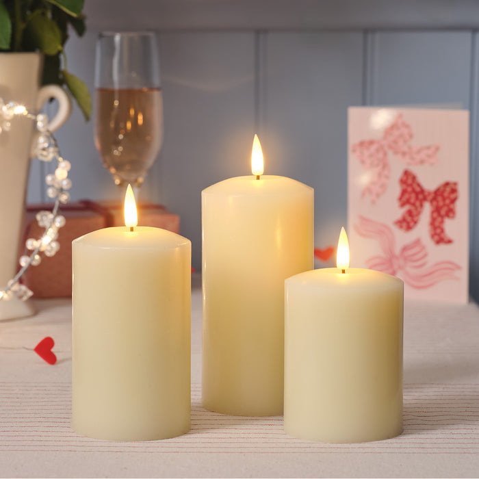 Three LED candles of different sizes on a table