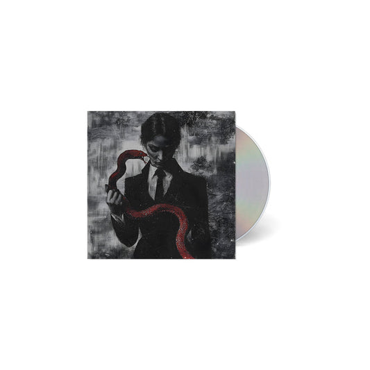A CD case from TX2, featuring dark art of a suited figure holding a red snake on a textured grayscale background. The partially visible, reflective CD is perfect for fans of Ice Nine Kills or Johnny 3 Tears.