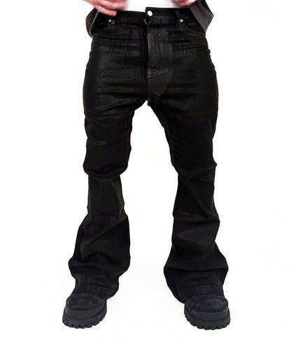 Model wearing oversized wideboy patchwork waxed denim jeans with flared silhouette in standing pose
